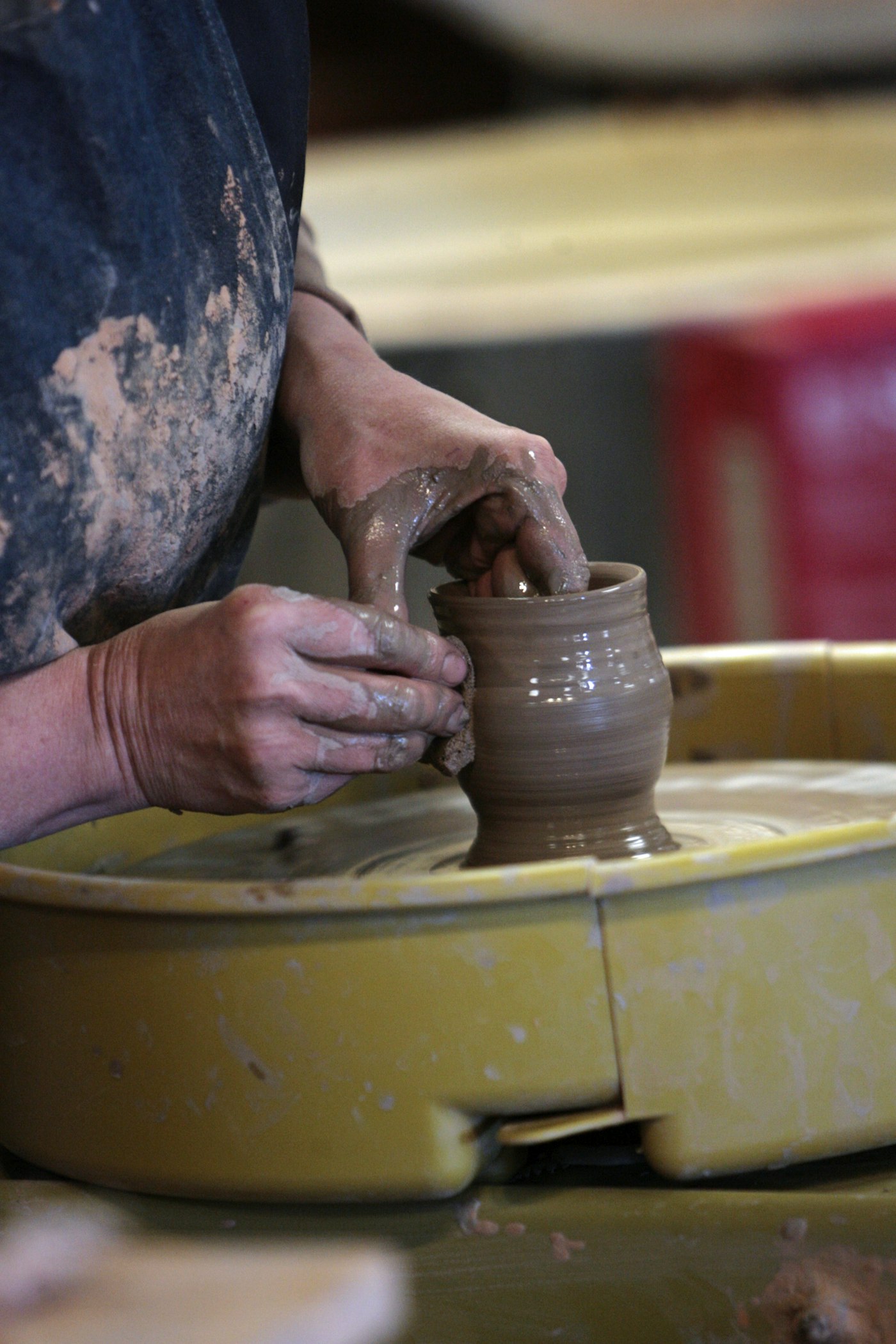 Potter's hands shaping a clay vase